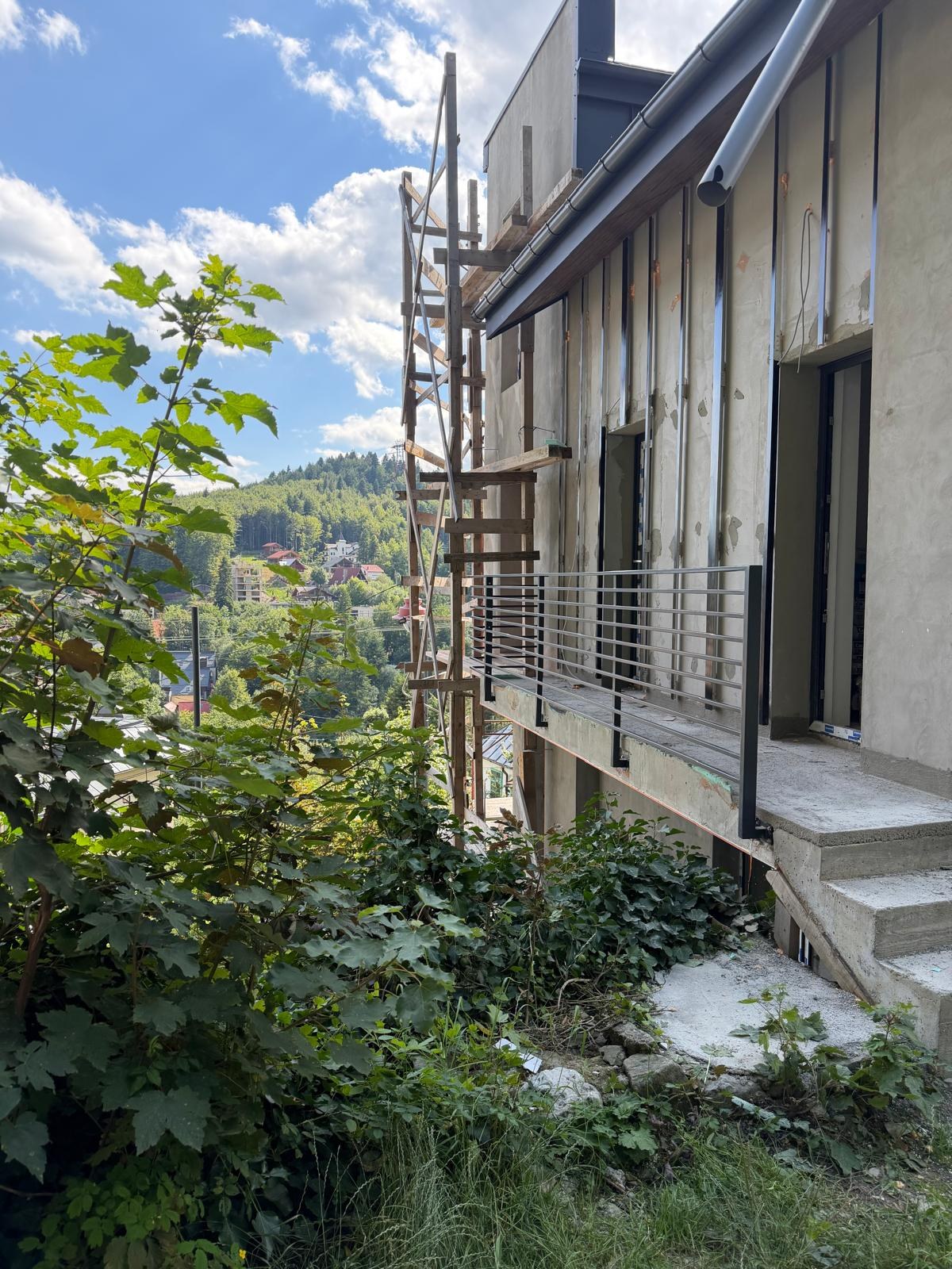 Detaliu balustradă neagră cu vedere spre peisajul montan